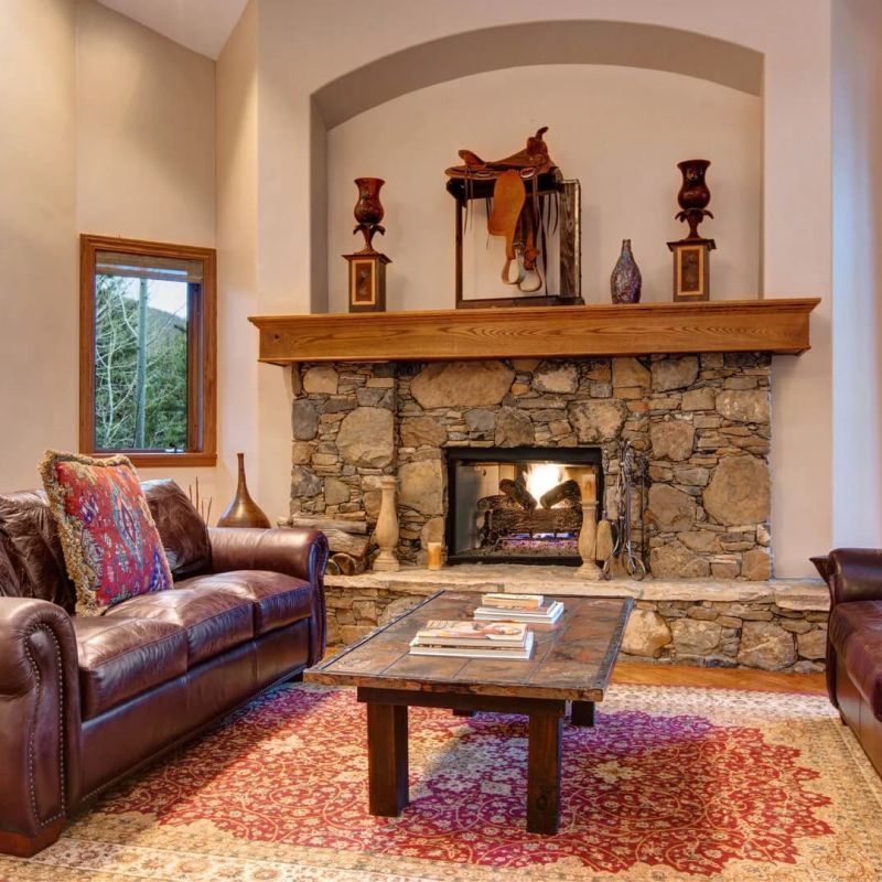 Western-style living room with stone fireplace and leather sofas