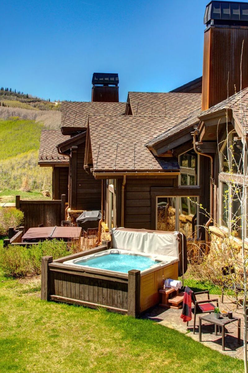 Backyard hot tub beside a timber-and-shingle mountain home