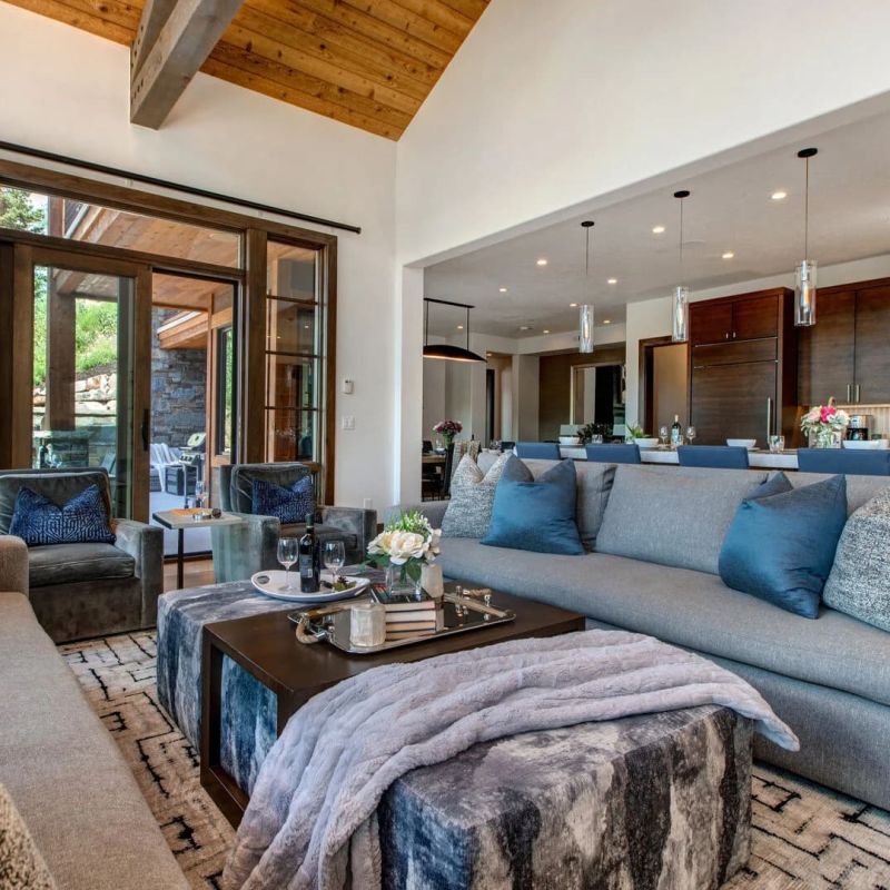 Modern living room with gray sectional opening to kitchen and patio