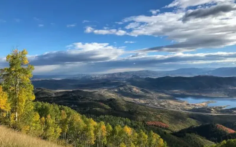 Aspen-framed overlook of fall foliage hills with a reservoir in the valley