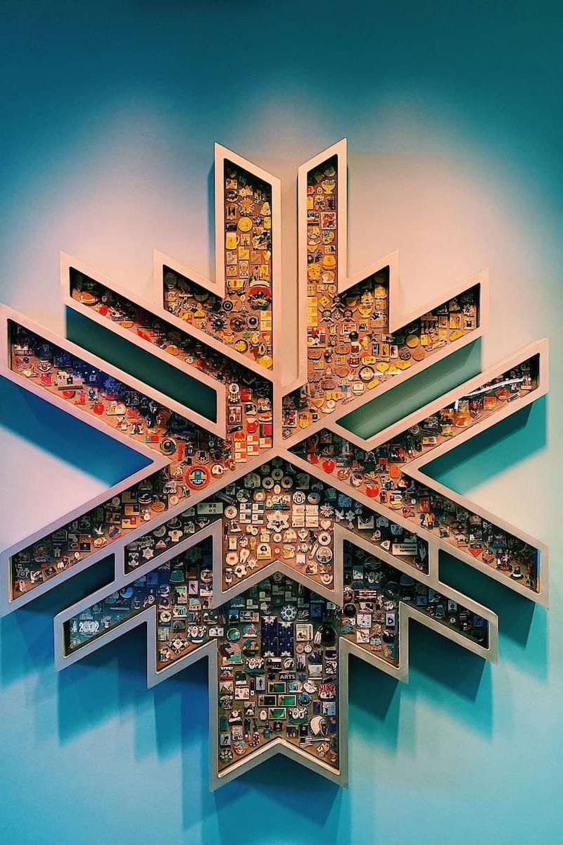 Snowflake-shaped wall display of Olympic and ski pin collection