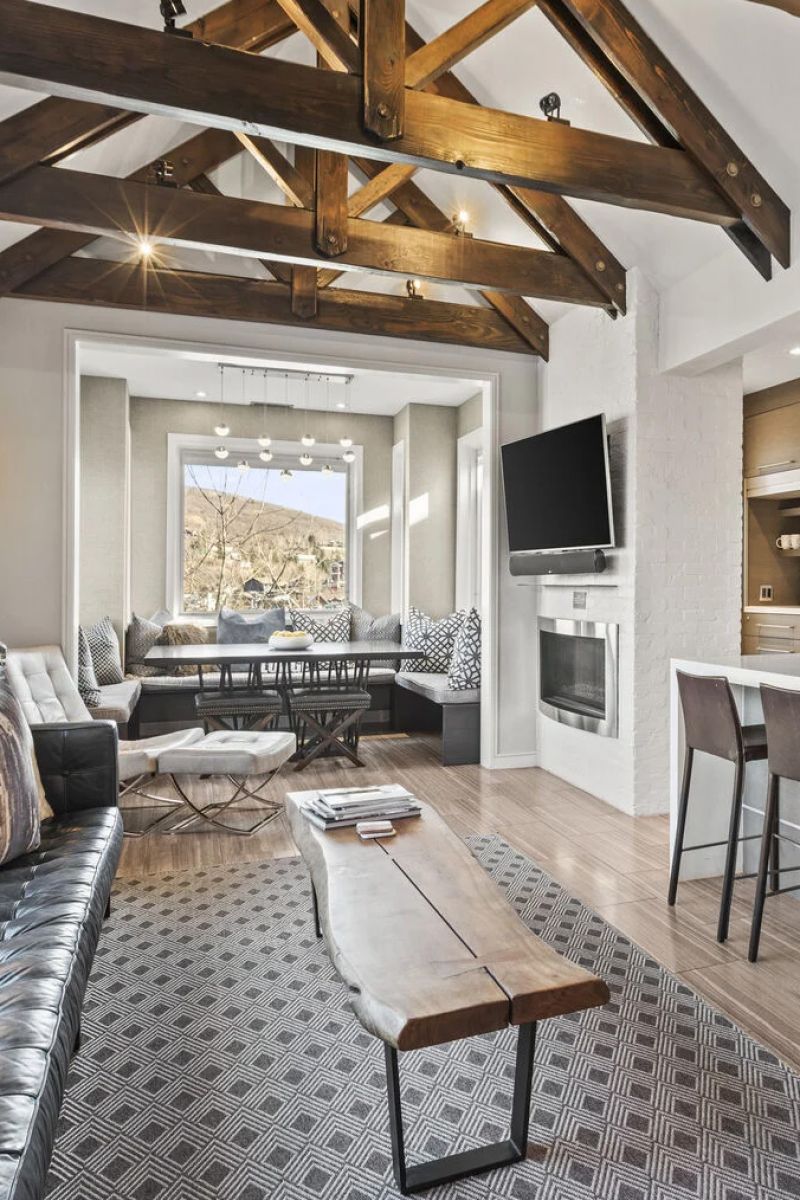 Living room with vaulted timber ceiling, fireplace, and wall-mounted television