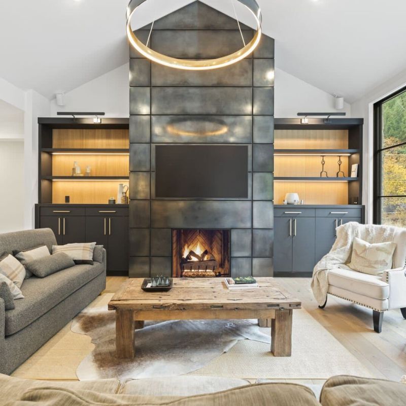 Modern living room with metal-paneled fireplace, built-in shelving, and wall-mounted TV