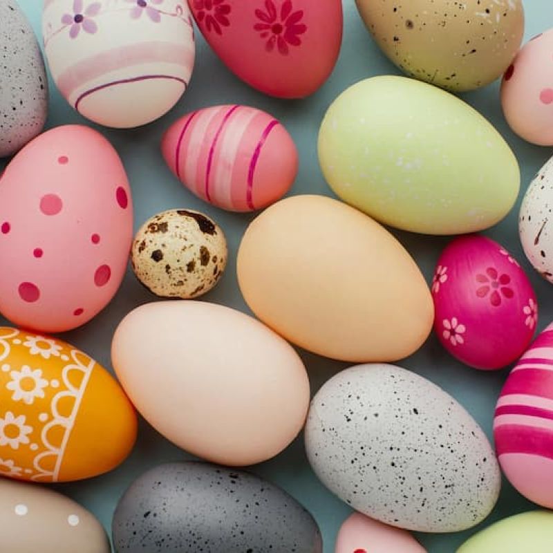 Painted Easter eggs in pastel colors arranged on a blue surface