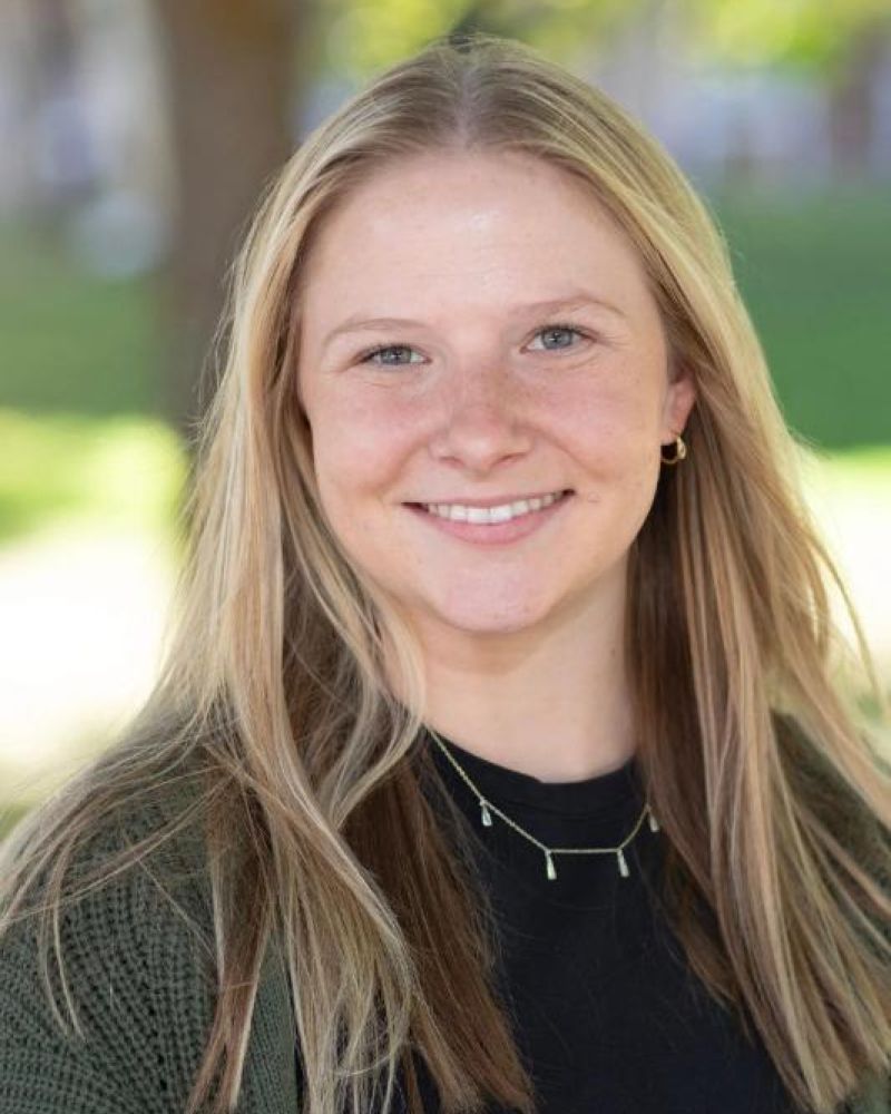 Headshot of a smiling woman with long blonde hair outdoors