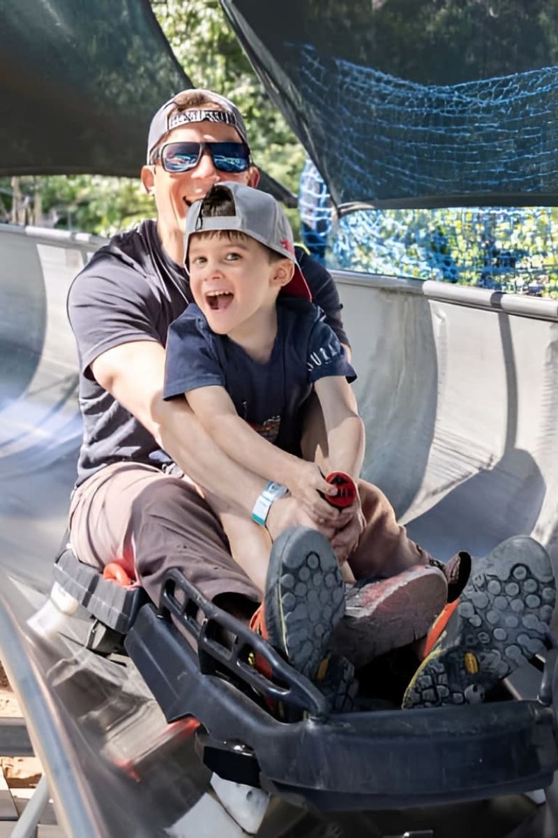 Father and son riding the alpine slide track at Utah Olympic Park
