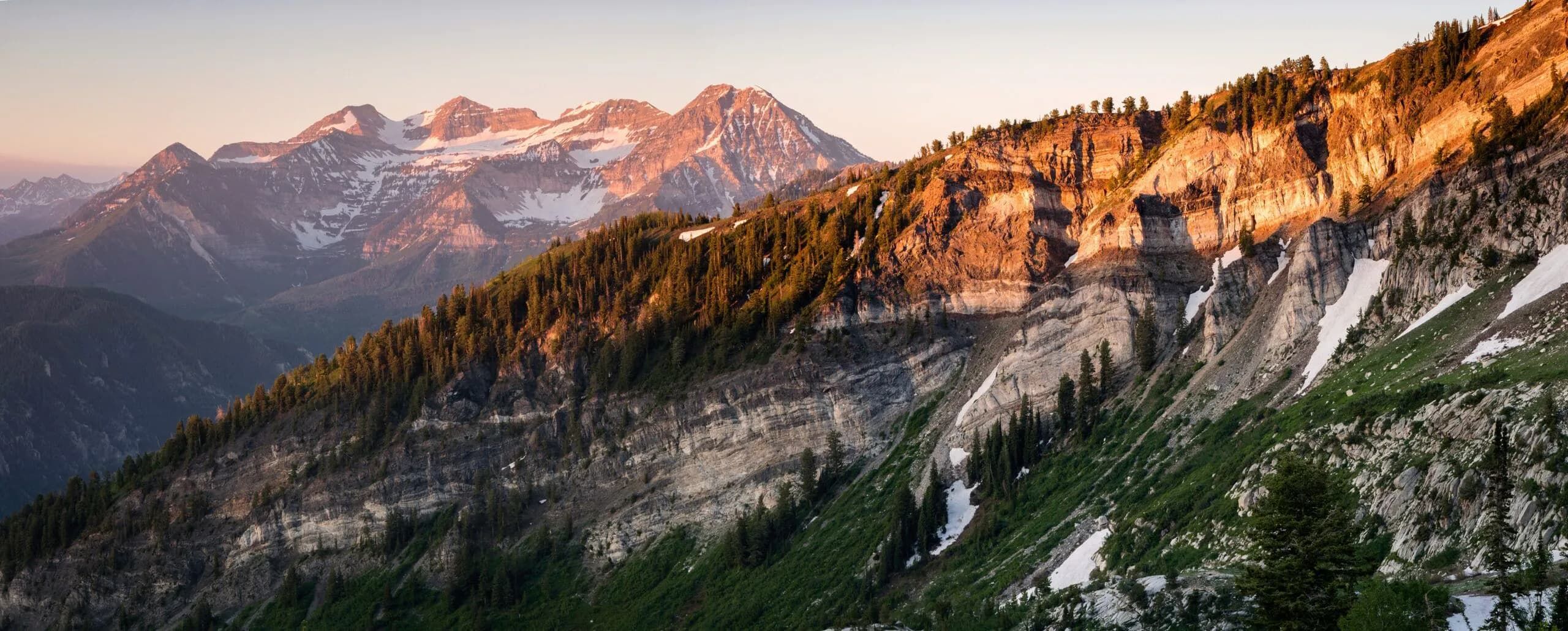 Mountain ridgeline at sunset with alpenglow on rocky cliffs