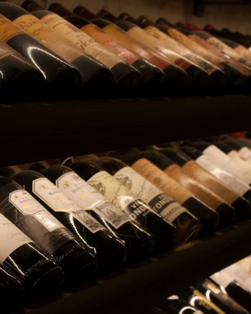 Rows of wine bottles stored on their sides in a cellar rack