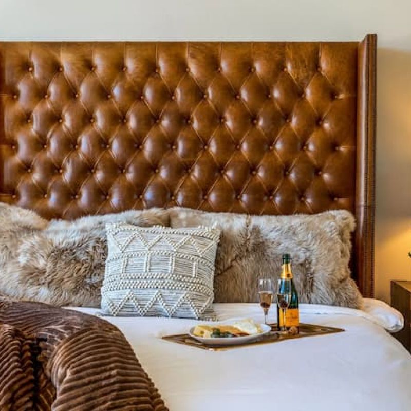 Bedroom with tufted leather headboard and breakfast tray on the bed
