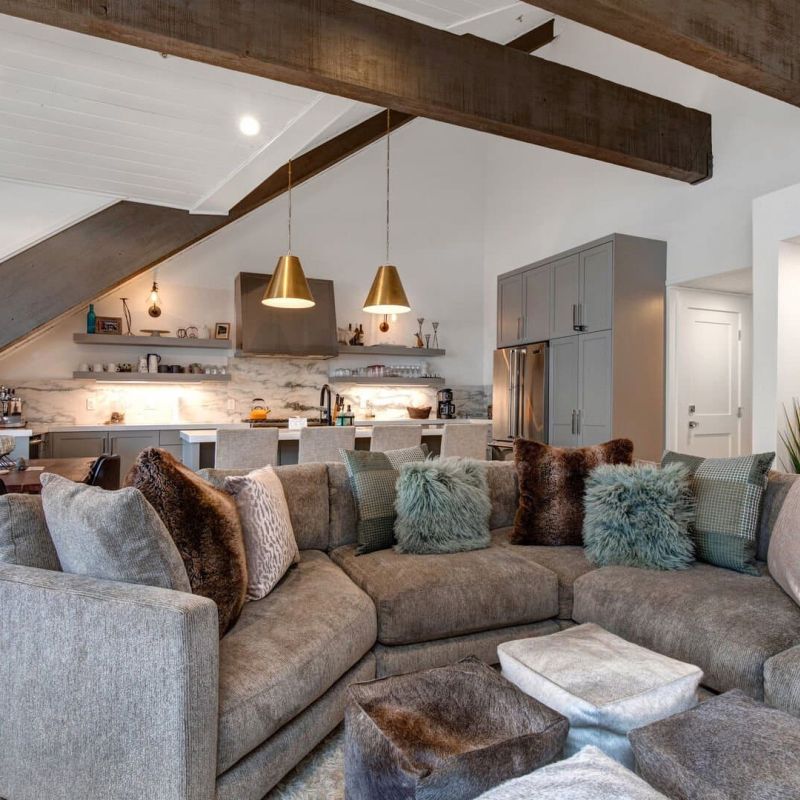 Open-concept living room with sectional sofa and exposed wood beams