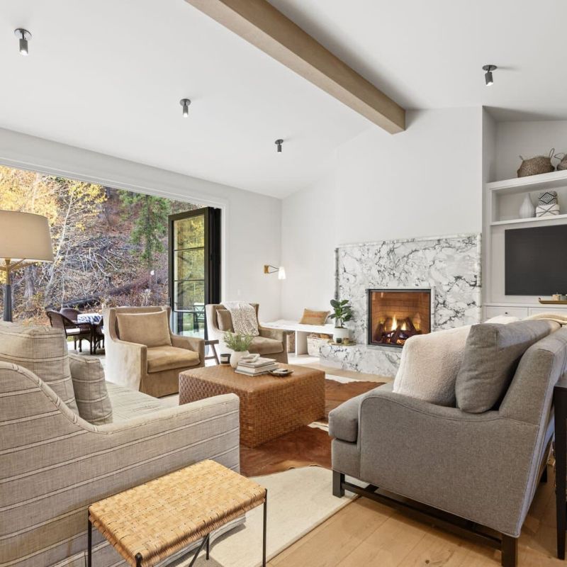 Living room with sectional sofa, marble fireplace, and built-in shelving