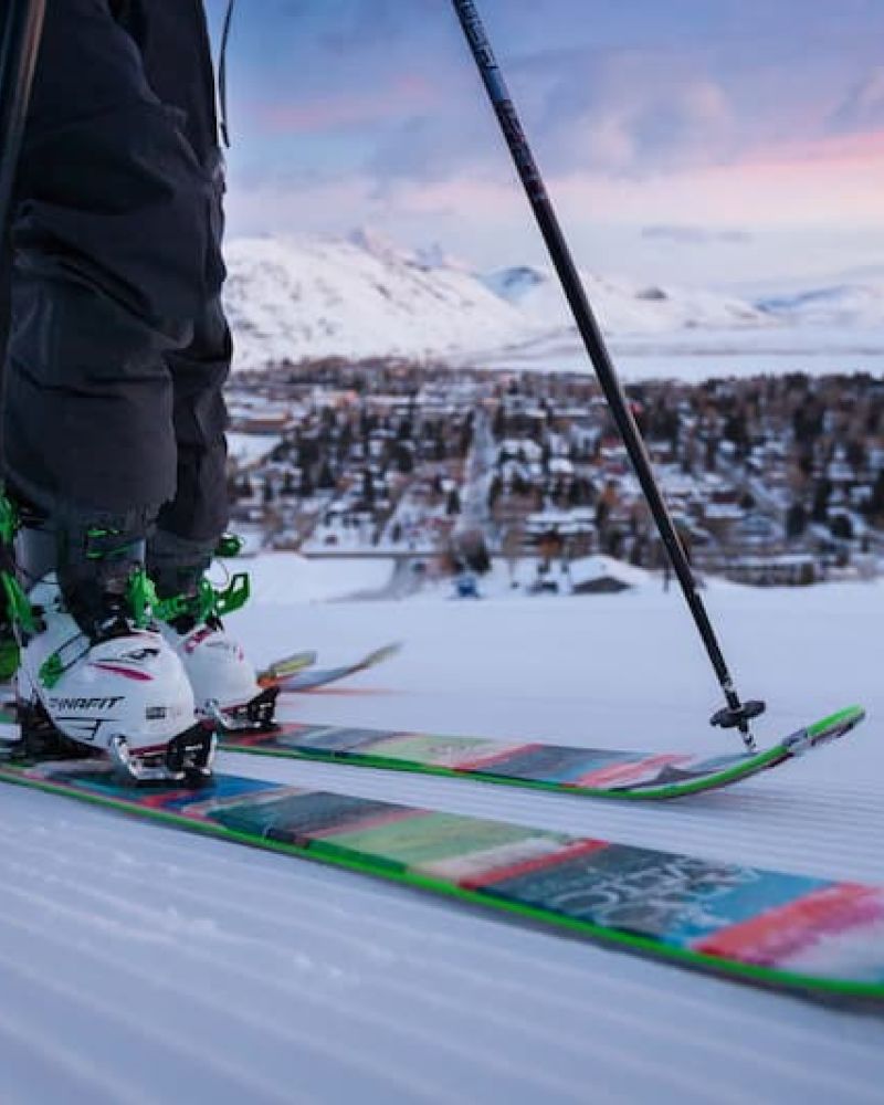 Skier on groomed run at sunrise above Jackson with Snow King logo