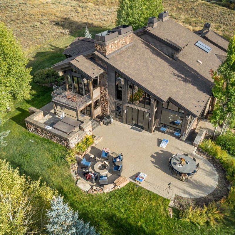 Aerial view of mountain home with patio, fire pit, and outdoor seating