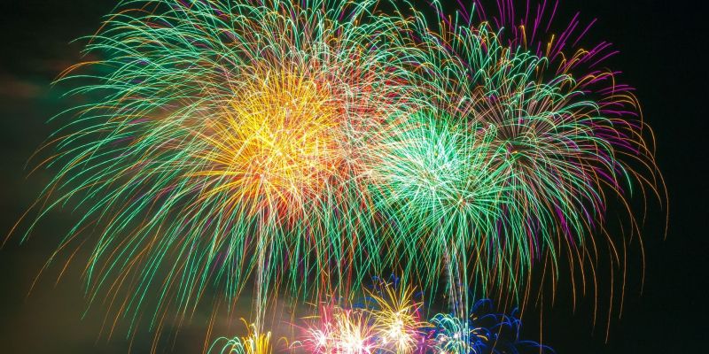 Multicolored fireworks lighting up the night sky over a town