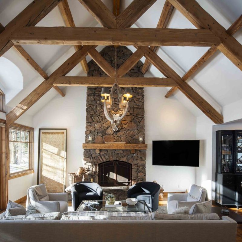 Great room with stone fireplace and timber truss ceiling