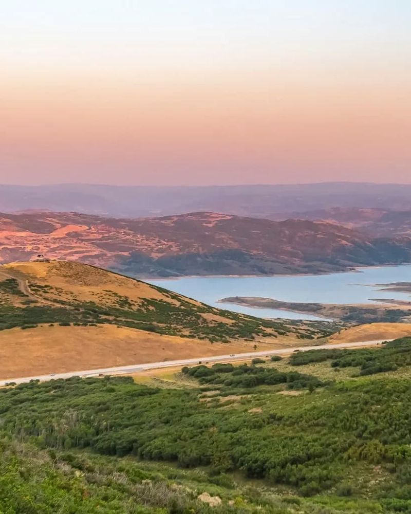 Sunset view over rolling hills and a winding reservoir