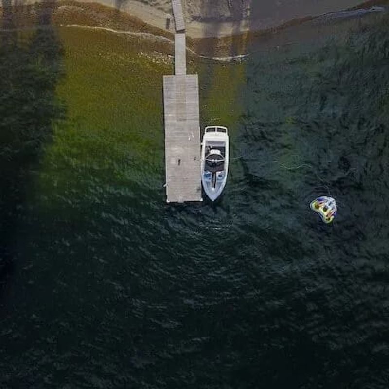 Aerial view of a motorboat moored at a dock with a tube floating nearby