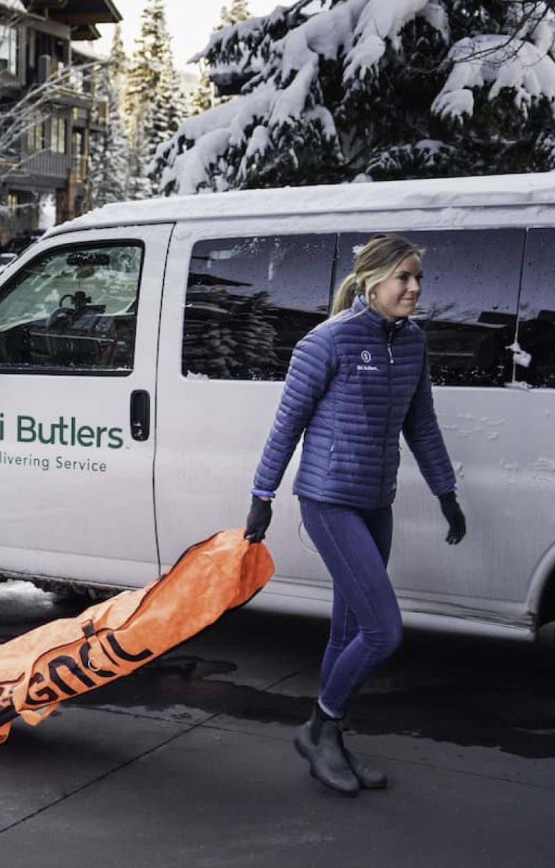 Ski Butlers delivery van with staff member carrying an Insignia ski bag