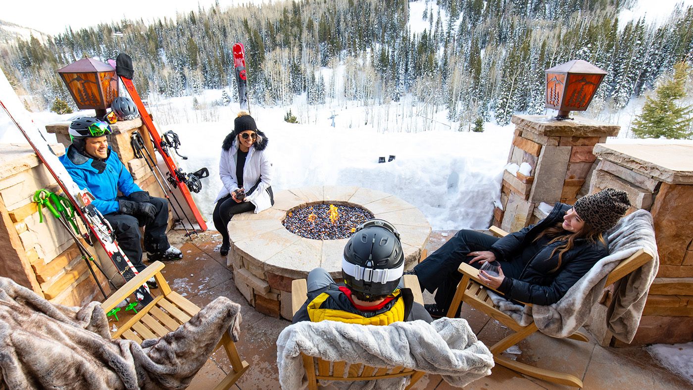 Ski group in Park City, Utah gather around fire pit