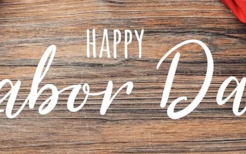 Happy Labor Day script lettering on weathered wood with American flag corners