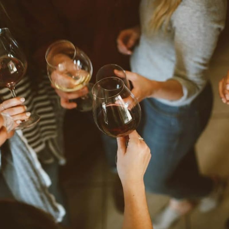 Overhead view of friends clinking red and white wine glasses