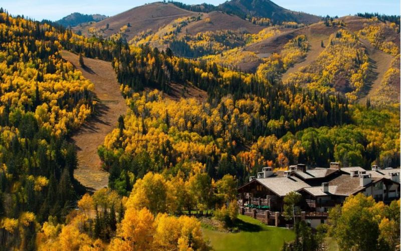 Mountain lodge nestled in a hillside of yellow autumn aspens
