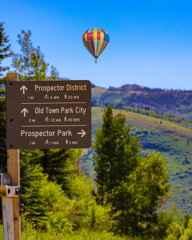 Trail signpost for Prospector District with hot air balloon overhead