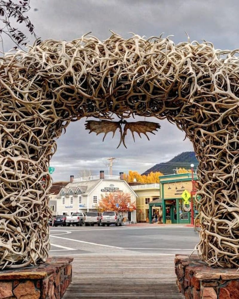 Elk antler arch framing Jackson Town Square shops on an overcast day