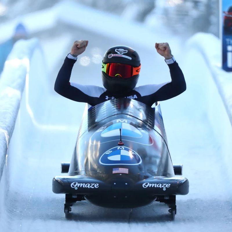Bobsled athlete celebrating at the finish of an icy track