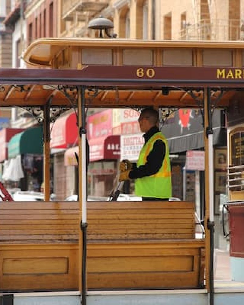 Vintage cable car operator standing aboard a Market Street trolley downtown