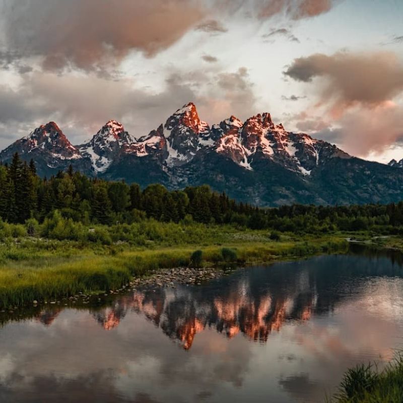 Grand Teton peaks at sunset reflected in a calm river