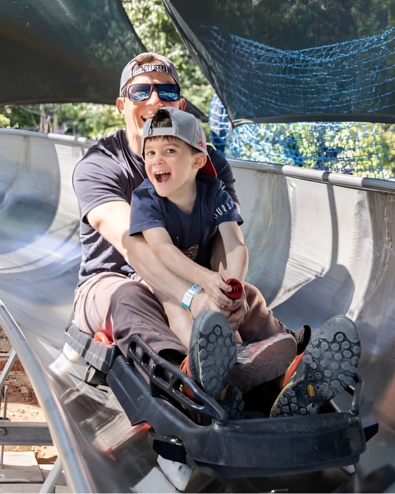 Father and son riding the alpine slide track at Utah Olympic Park