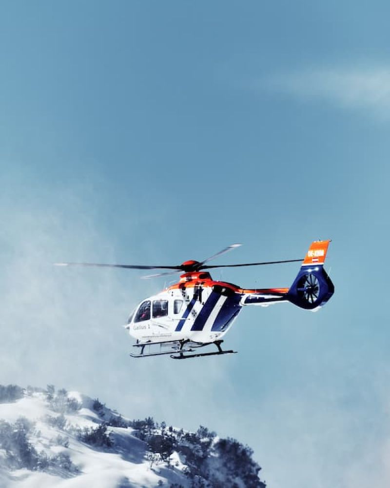 Helicopter flying past a snow-covered mountainside