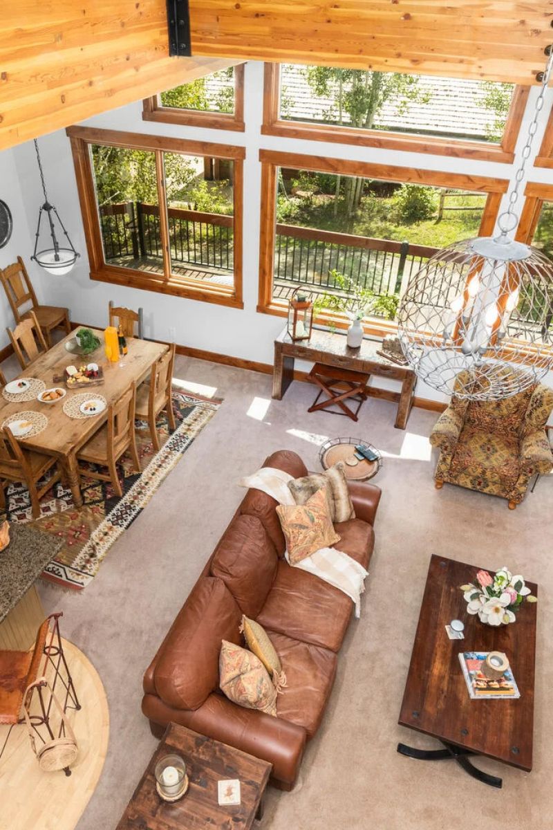 Overhead view of a timber-framed living and dining room with leather sofa