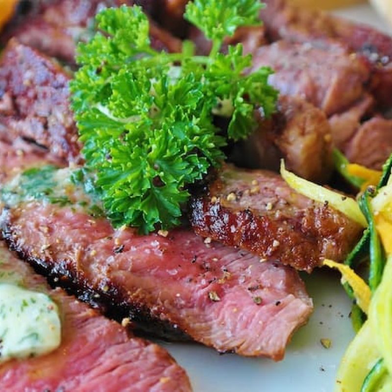 Sliced grilled steak with herb butter and zucchini noodles