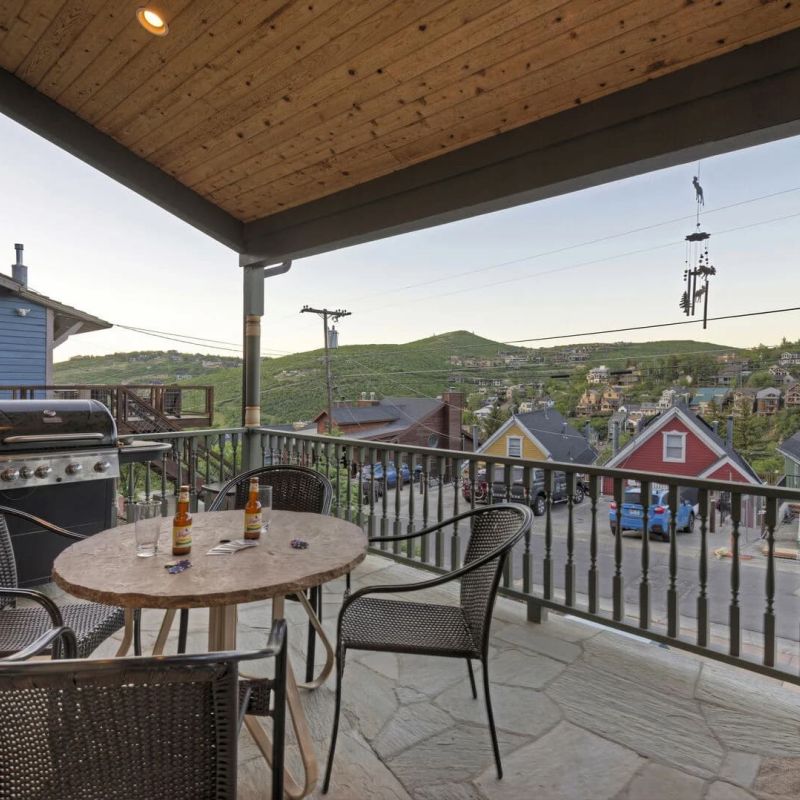Covered Park City porch with bistro table, gas grill, and view of historic Old Town houses