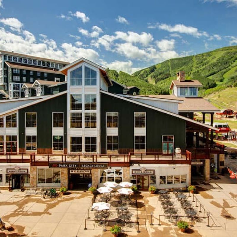 Park City Legacy Lodge exterior with patio seating and ski runs behind
