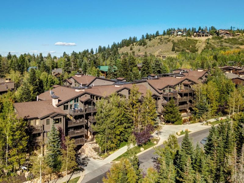 Hillside cluster of timber-and-stone Park City condos surrounded by pines and aspens