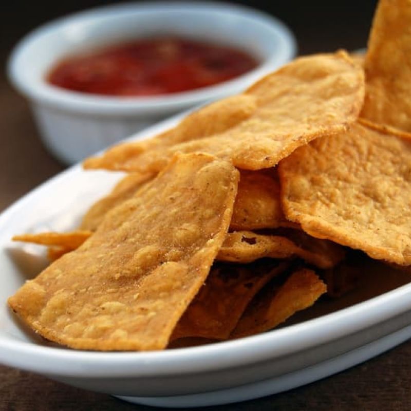 Tortilla chips and salsa in white serving dishes