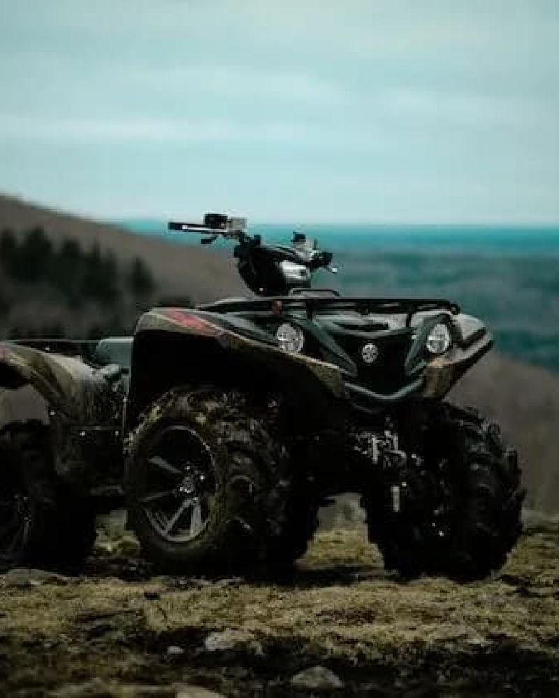 ATV parked on a ridge overlooking rolling hills at dusk