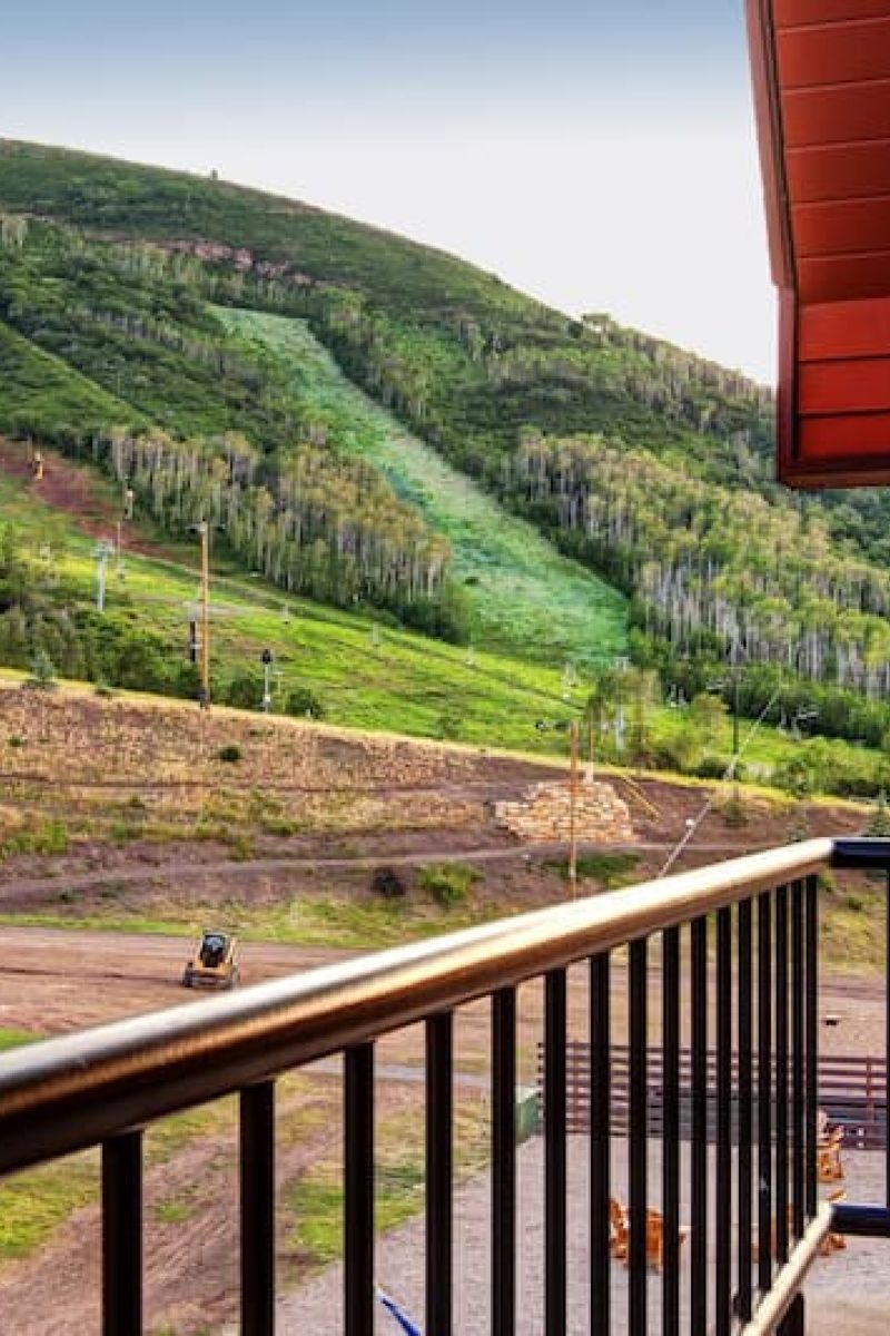 Balcony view of green Park City ski runs and chairlift