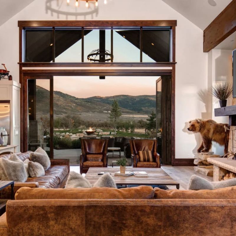 Mountain home living room with leather sofas opening to patio and valley views