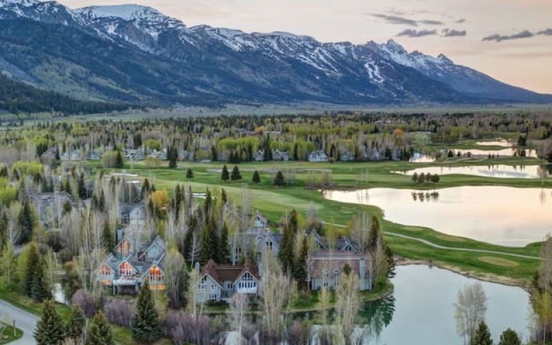 Aerial view of Teton range and ponds at sunset over a Jackson Hole golf community
