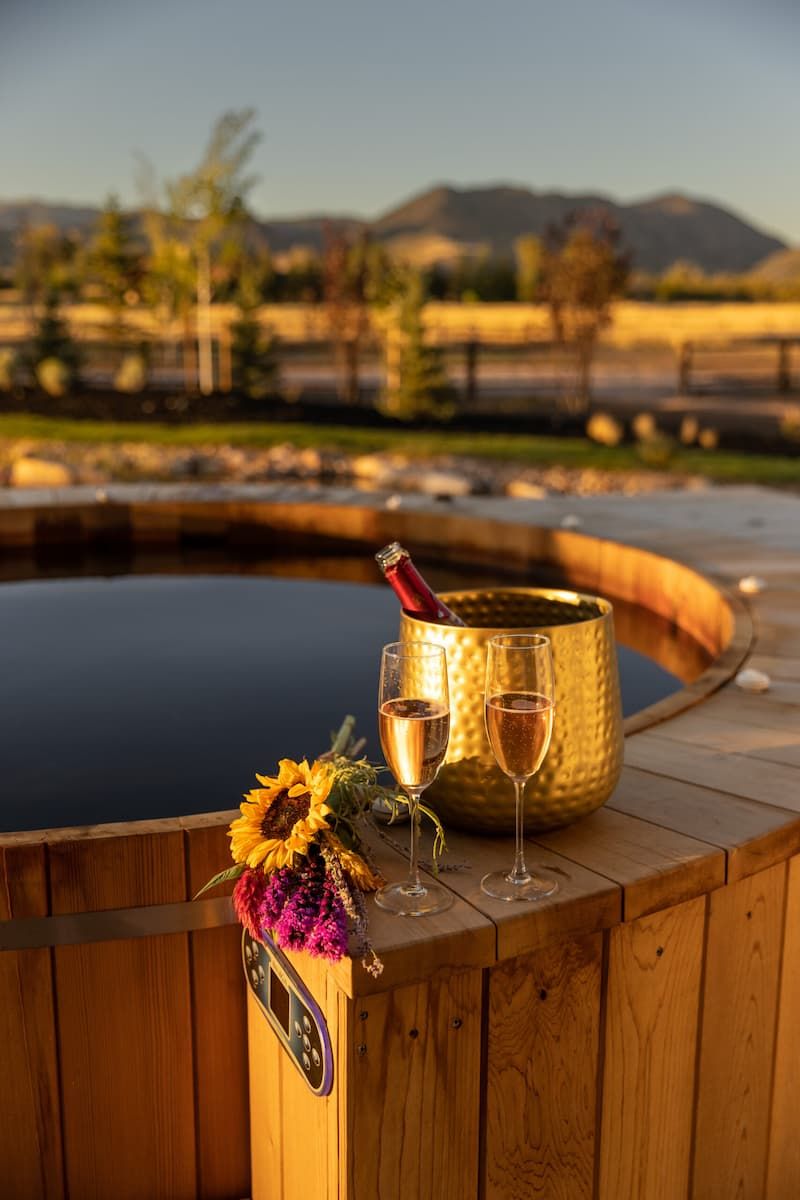 Cedar hot tub with champagne and sunflowers overlooking Jackson Hole mountains