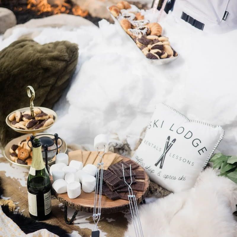 Snowy fireside picnic with sparkling wine, smores fixings, and a Ski Lodge pillow
