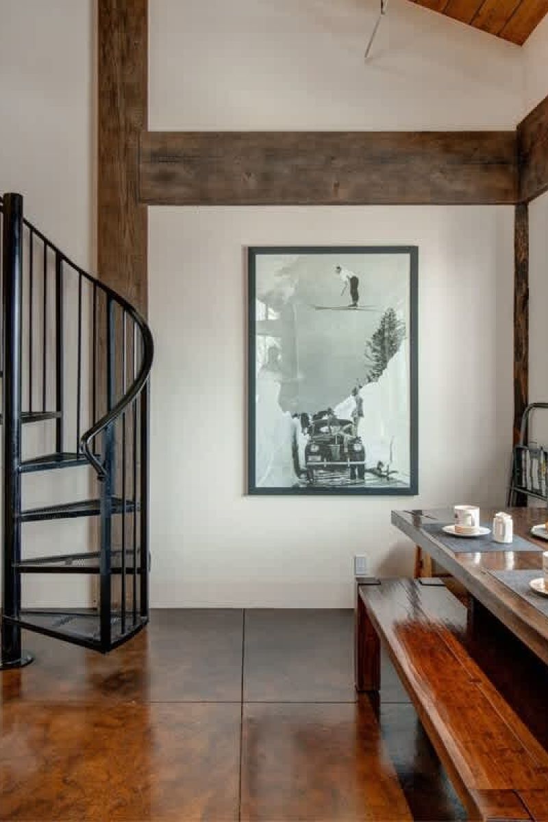 Mountain home dining nook with spiral staircase and ski photograph