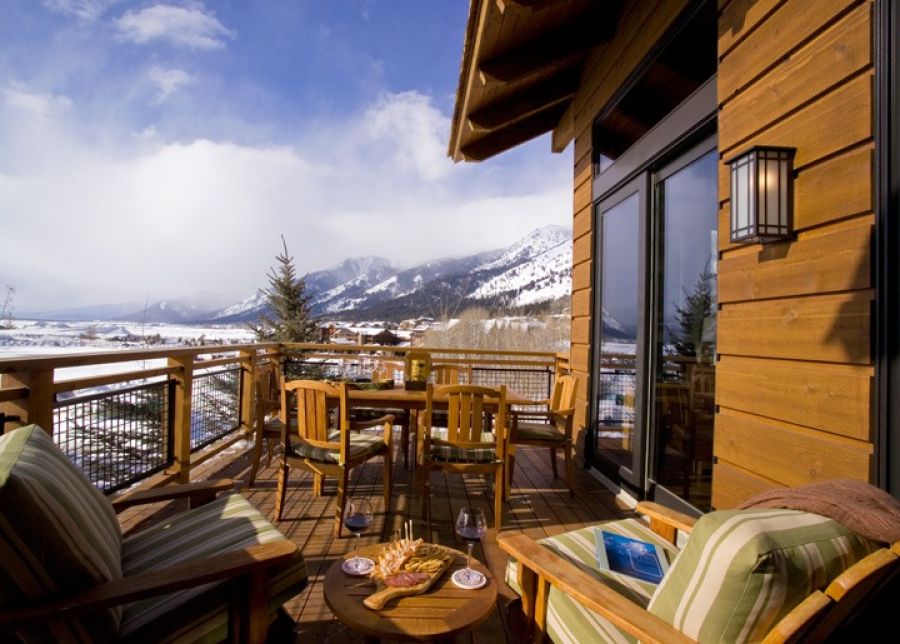 Wood deck with cafe table and chairs overlooking snow-covered Jackson Hole valley