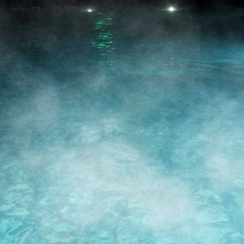 Steam rising from a heated outdoor pool at night