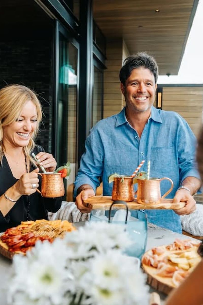 Group of friends enjoying drinks and charcuterie at an outdoor table